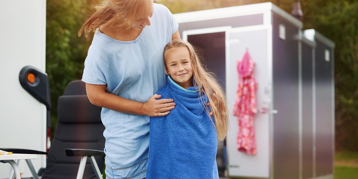 Moeder en dochter voor Huusq sanitair unit op de camping