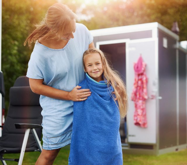 Moeder en dochter bij een Huusq sanitair unit op de camping