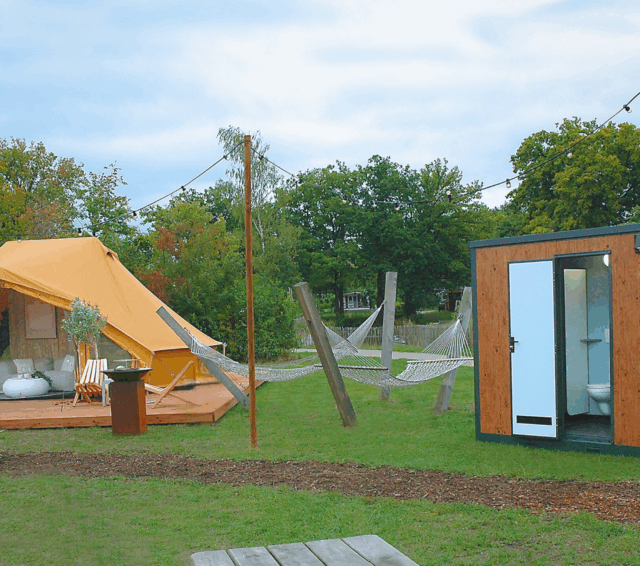 Huusq sanitair unit naast een safaritent op de camping
